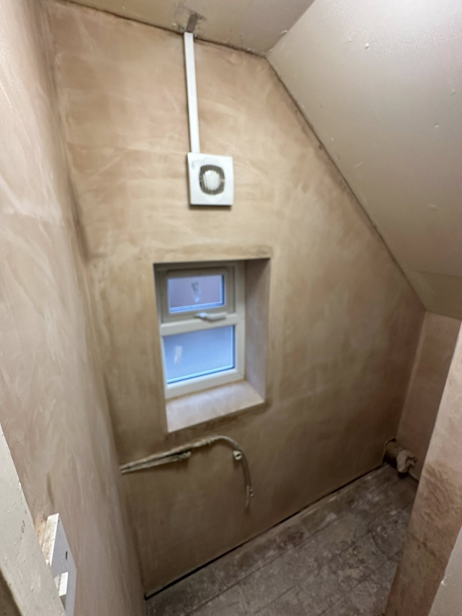 Unfinished attic room with window and exposed walls