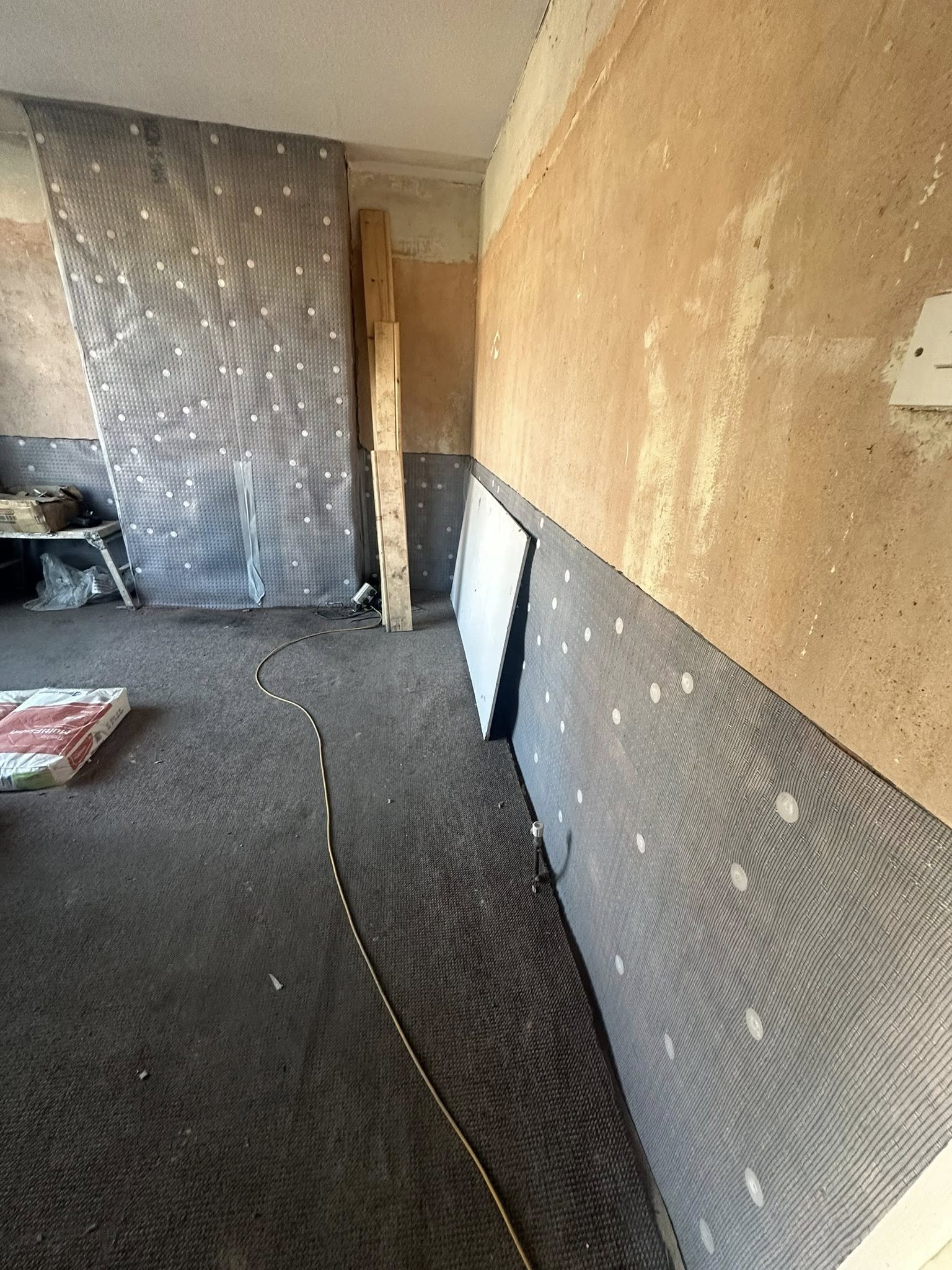 Interior room renovation in progress with protective sheeting
