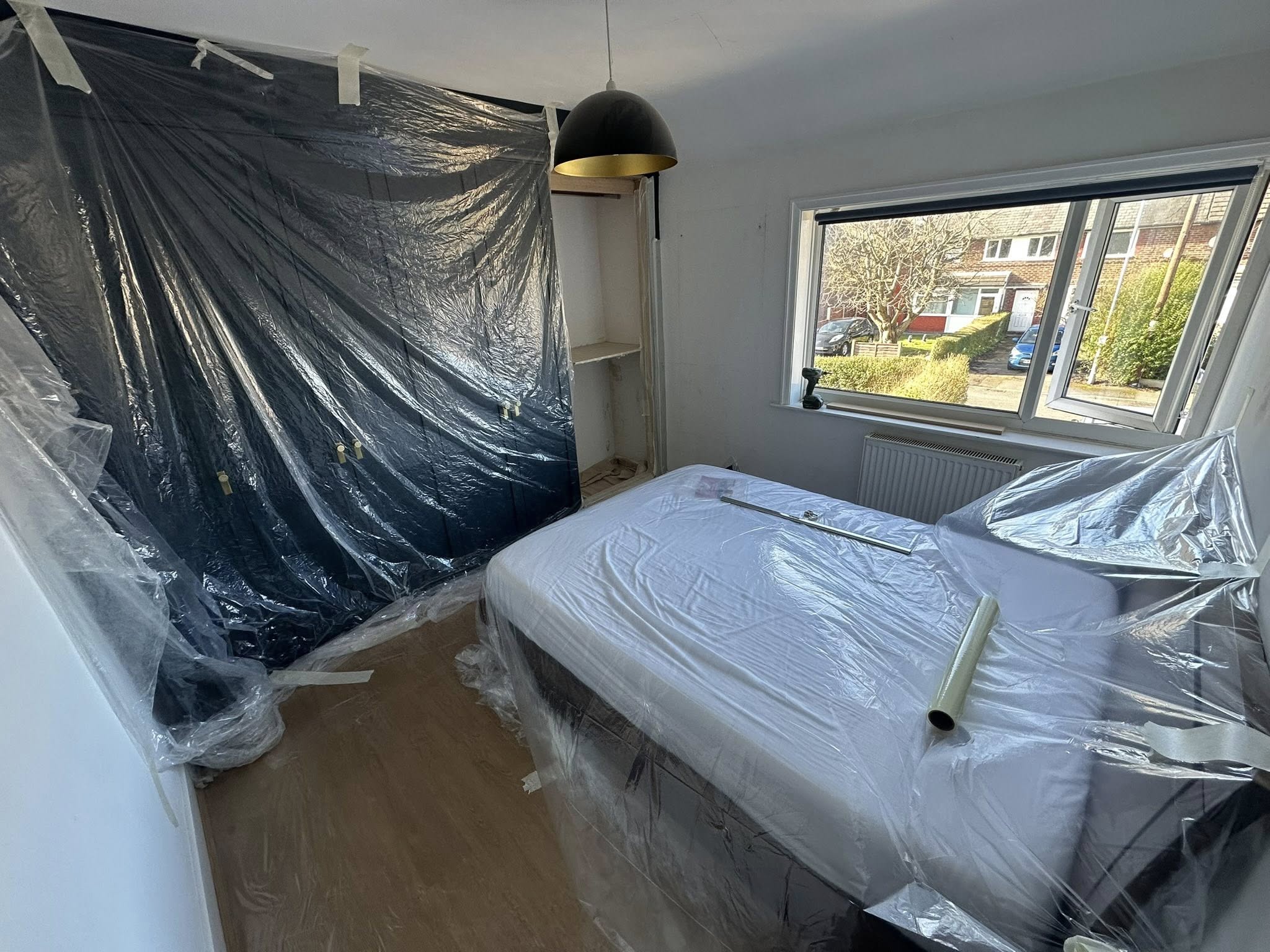 Bedroom under renovation with protective sheeting