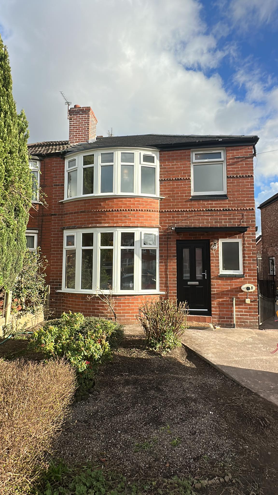 Renovated brick residential house exterior with bay windows
