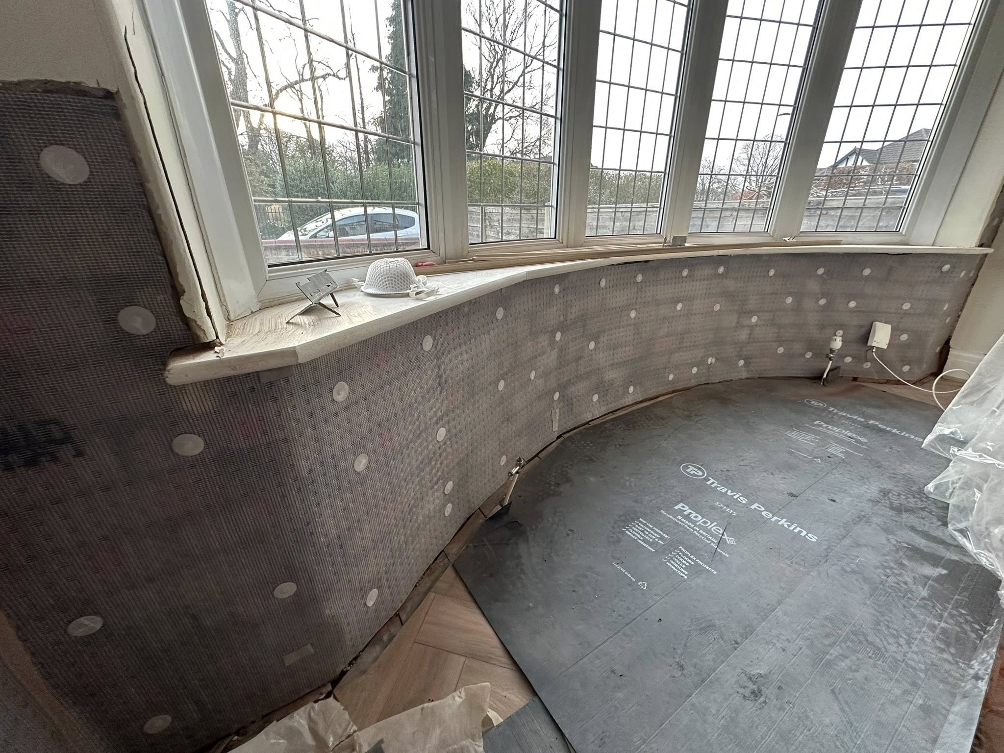 Bay window room with protective sheeting during renovation